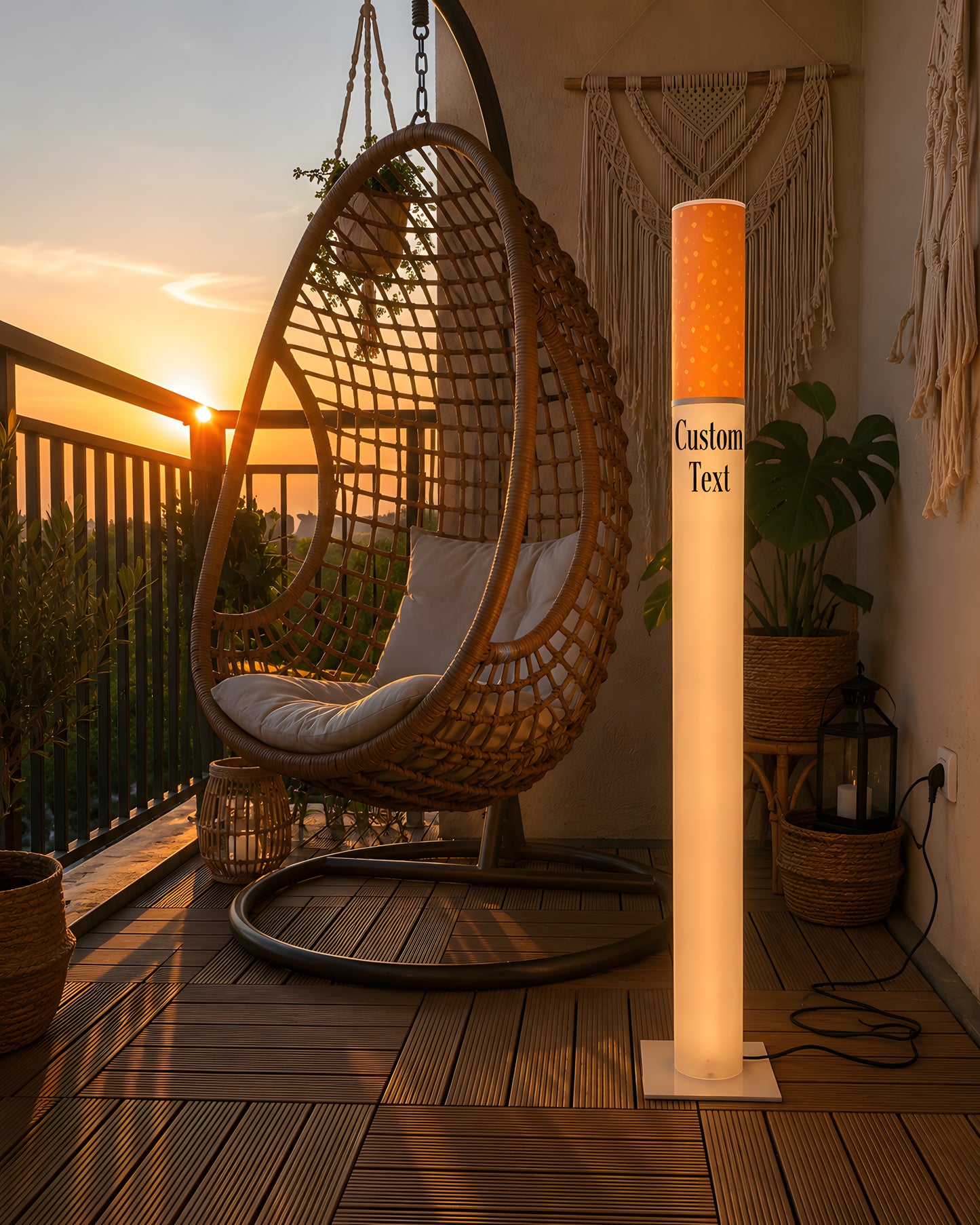 Giant cigarette floor lamp 95 cm lit on a wooden balcony at sunset next to a rattan hanging egg chair and macrame decor