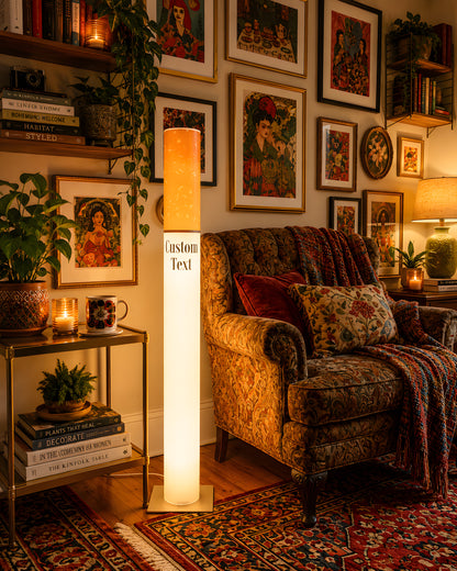 Retro cigarette lamp lighting an eclectic bohemian living room with a floral armchair and a full gallery wall of framed art