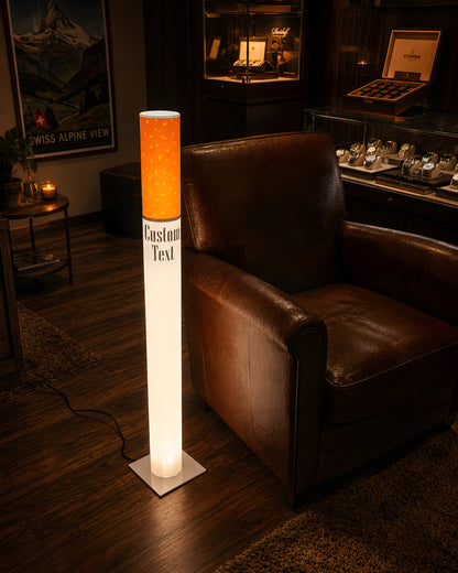 Vintage giant cigarette lamp glowing beside a brown leather club armchair in a dark wood den with a whiskey display cabinet