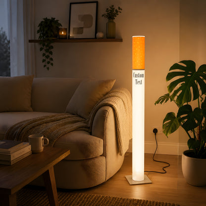 Giant cigarette lamp 95 cm as ambient lighting in a bright modern living room with a cream curved sofa and monstera plant