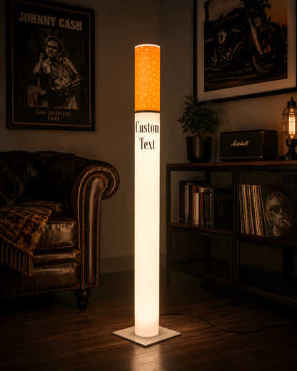 Giant cigarette lamp lighting a music room with a chesterfield sofa, vinyl record shelf, guitar amp and rock posters
